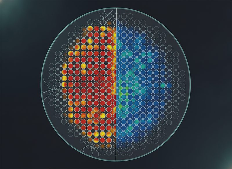 Residual-stress heat map of a TGV array showing cracks between vias at tight pitch and crack-free walls at wider pitch.